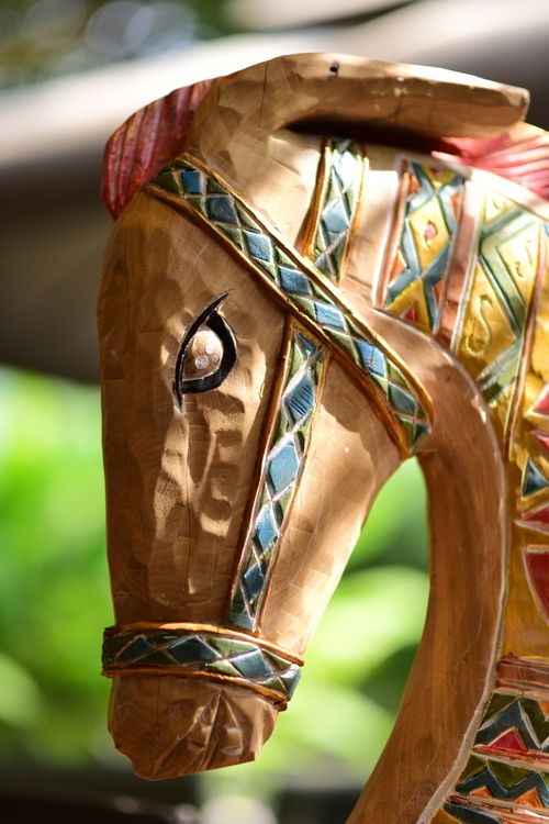 Free Close-up of a colorful, intricately carved wooden horse head sculpture with geometric patterns. Stock Photo