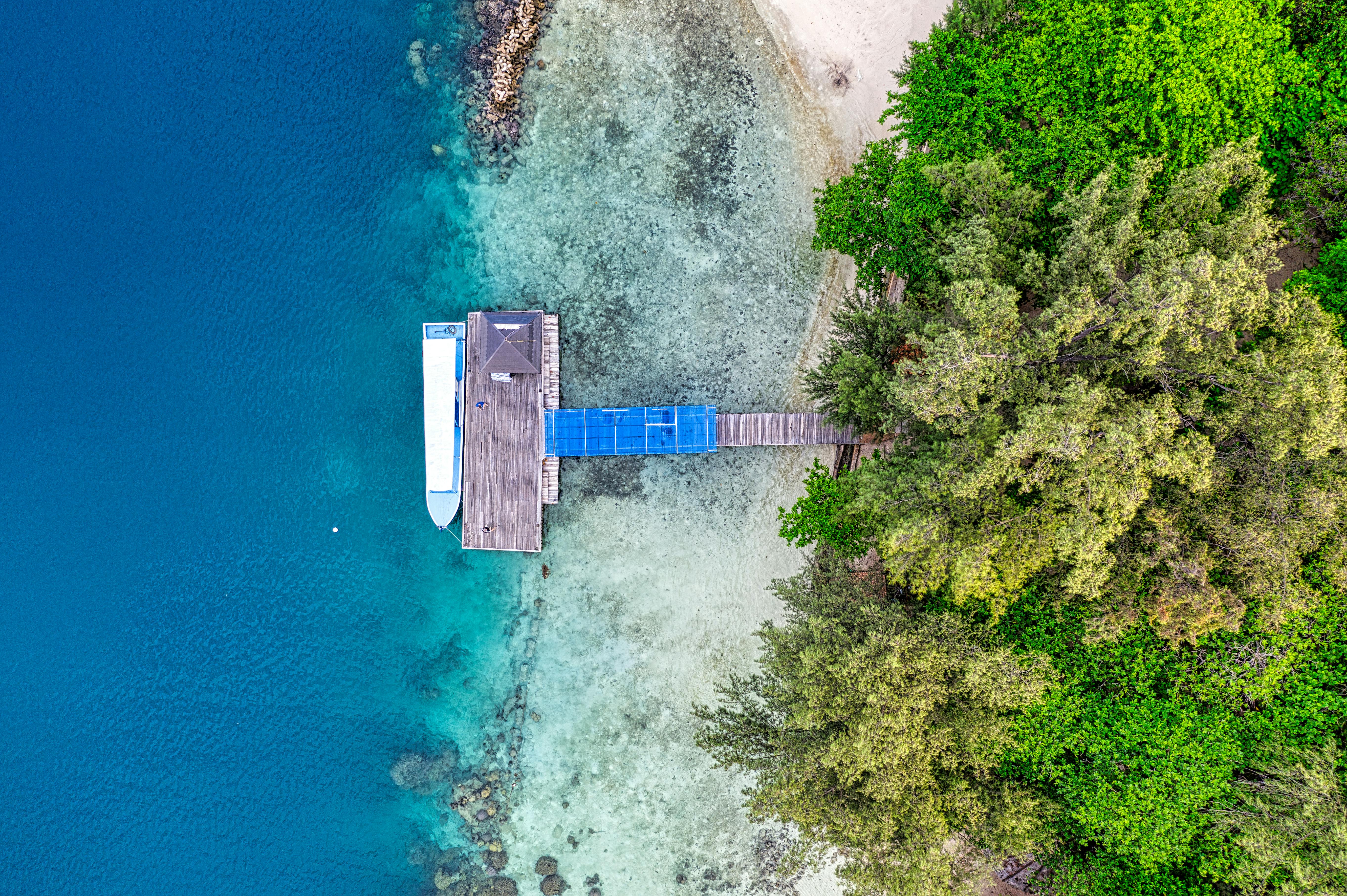 bird s eye view photography of blue and gray wooden dock on shoreline