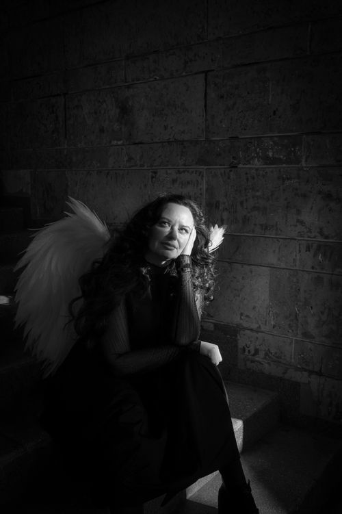 Free Black and white portrait of a woman with angel wings in a gothic setting, exuding mystery. Stock Photo