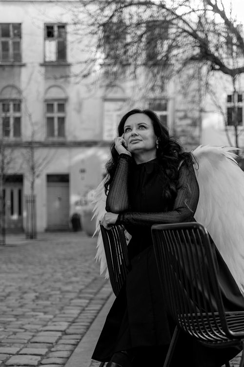 Free A contemplative woman with angel wings sits outdoors in Lviv, Ukraine. Stock Photo