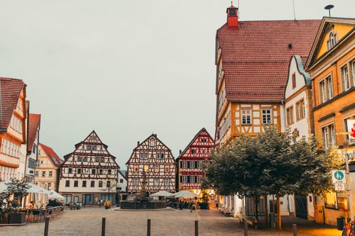 Free Picturesque European square featuring traditional half-timbered buildings at twilight. Stock Photo