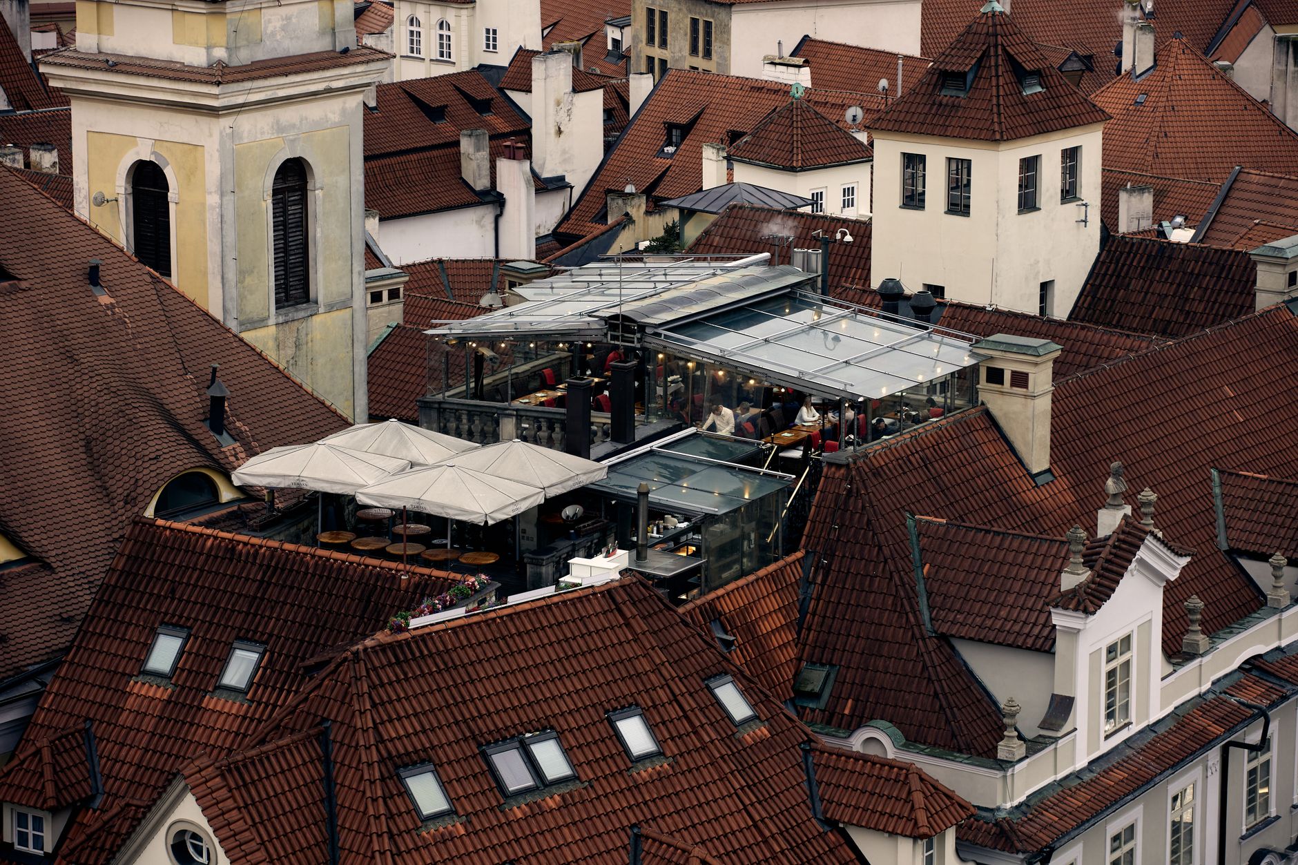Charming rooftop restaurant on terracotta rooftops in an historic European city.