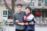 Two Friends Embracing Outdoors with Bicycles