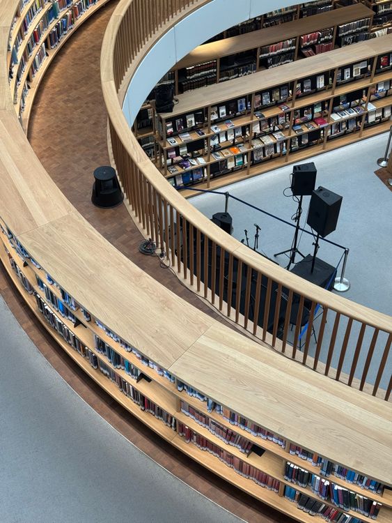 Modern library interior with curved shelves and stage · Free Stock Photo