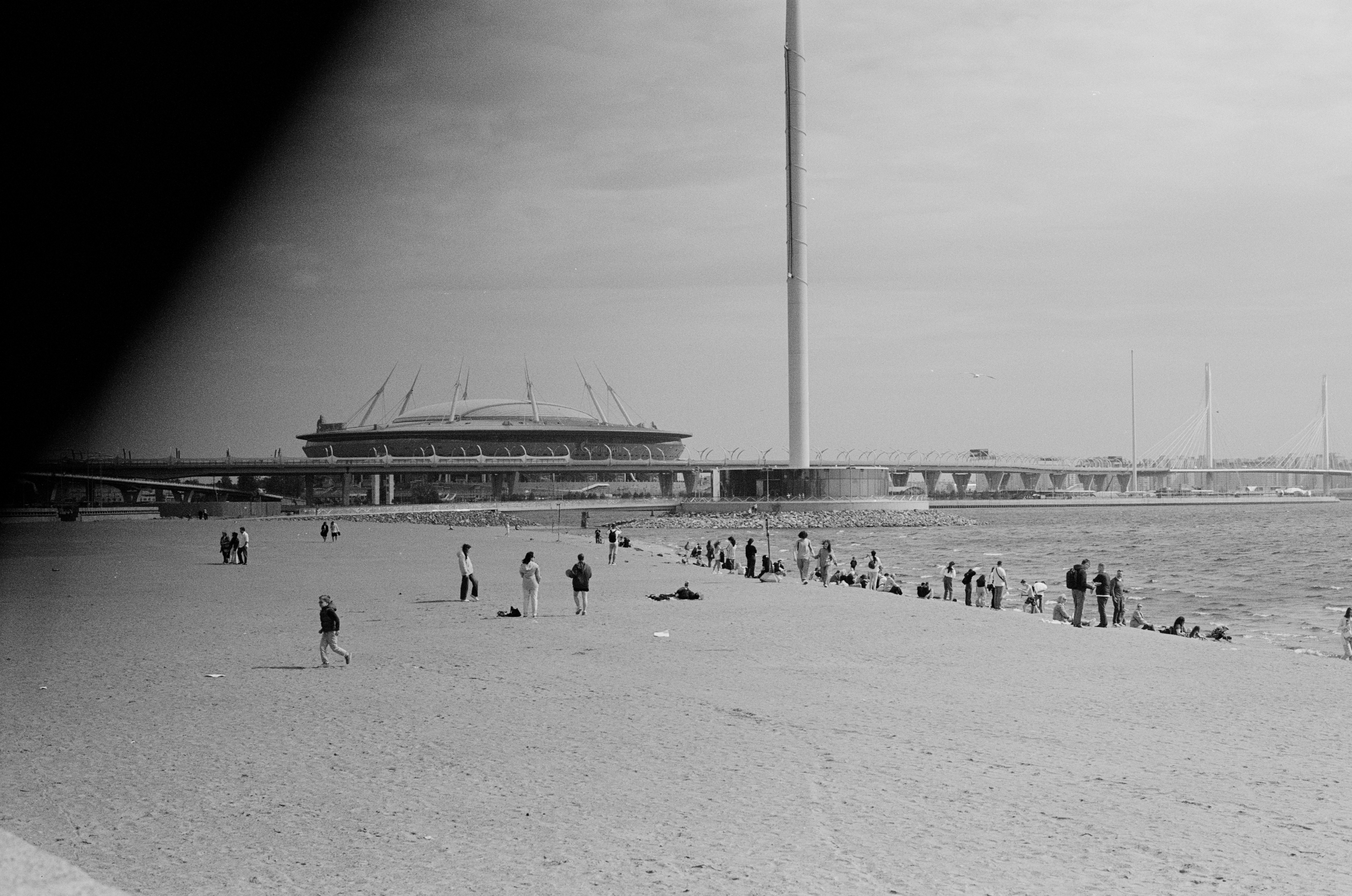 Scenic beach view in Saint Petersburg with people and a distinctive landmark. Calm and peaceful setting.