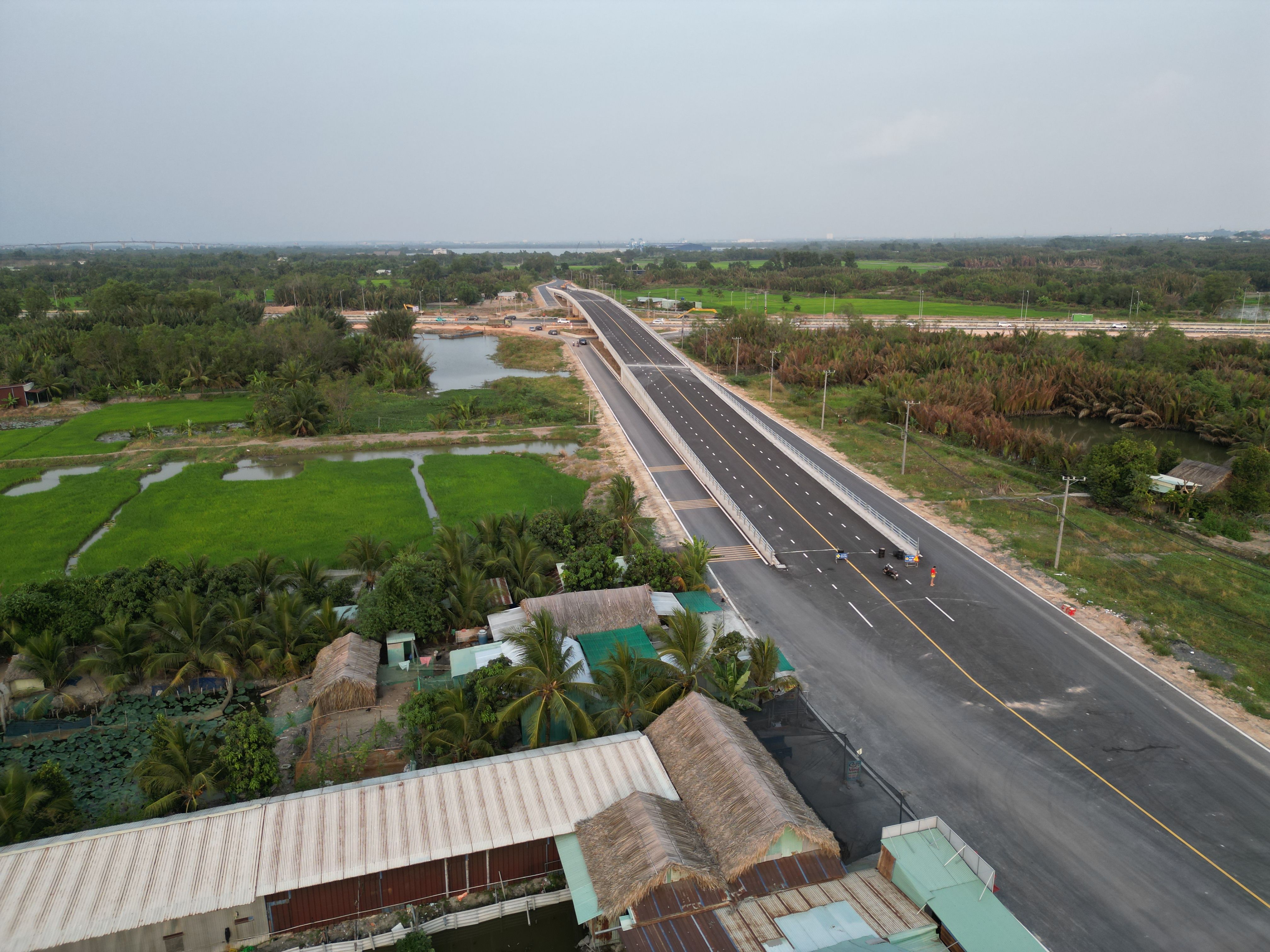 Aerial view of a newly constructed road in Đồng Nai, Vietnam, surrounded by lush greenery.