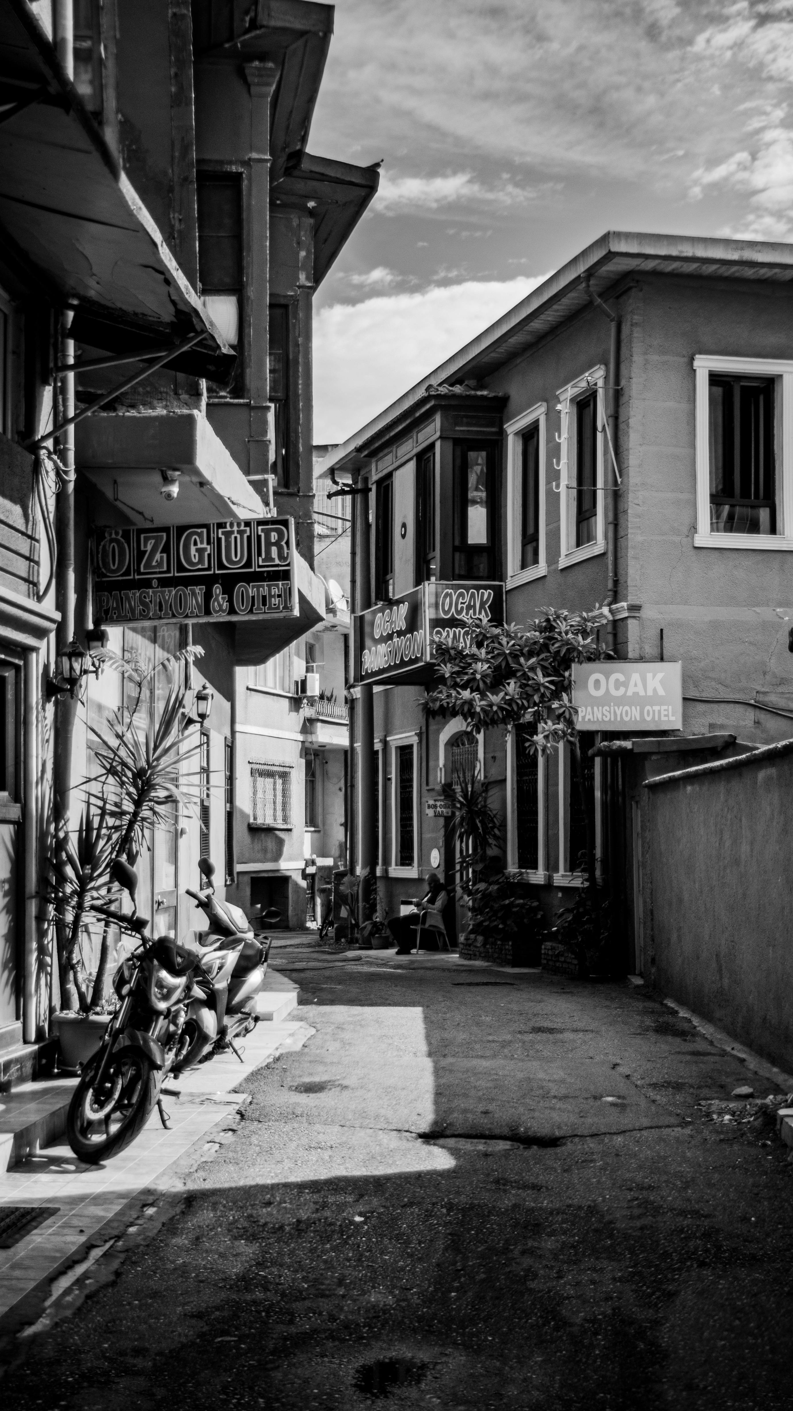 Charming black and white photo of a quiet town street featuring quaint architecture and signage.