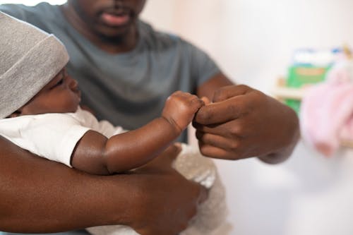 Foto De Foco Raso De Homem Carregando Seu Bebê