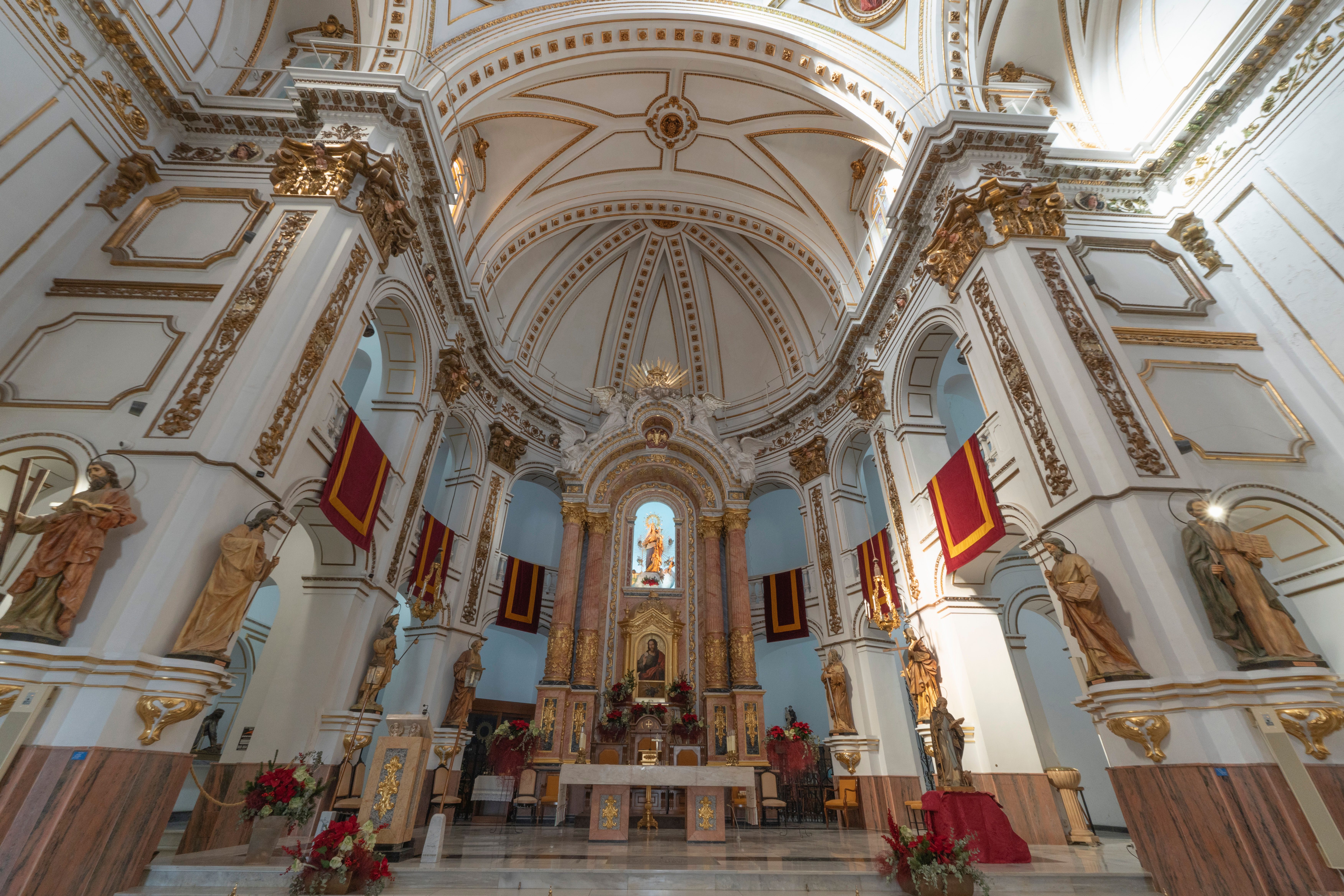 Intricate interior of the Basilica of Altea, showcasing detailed architecture and religious statues.