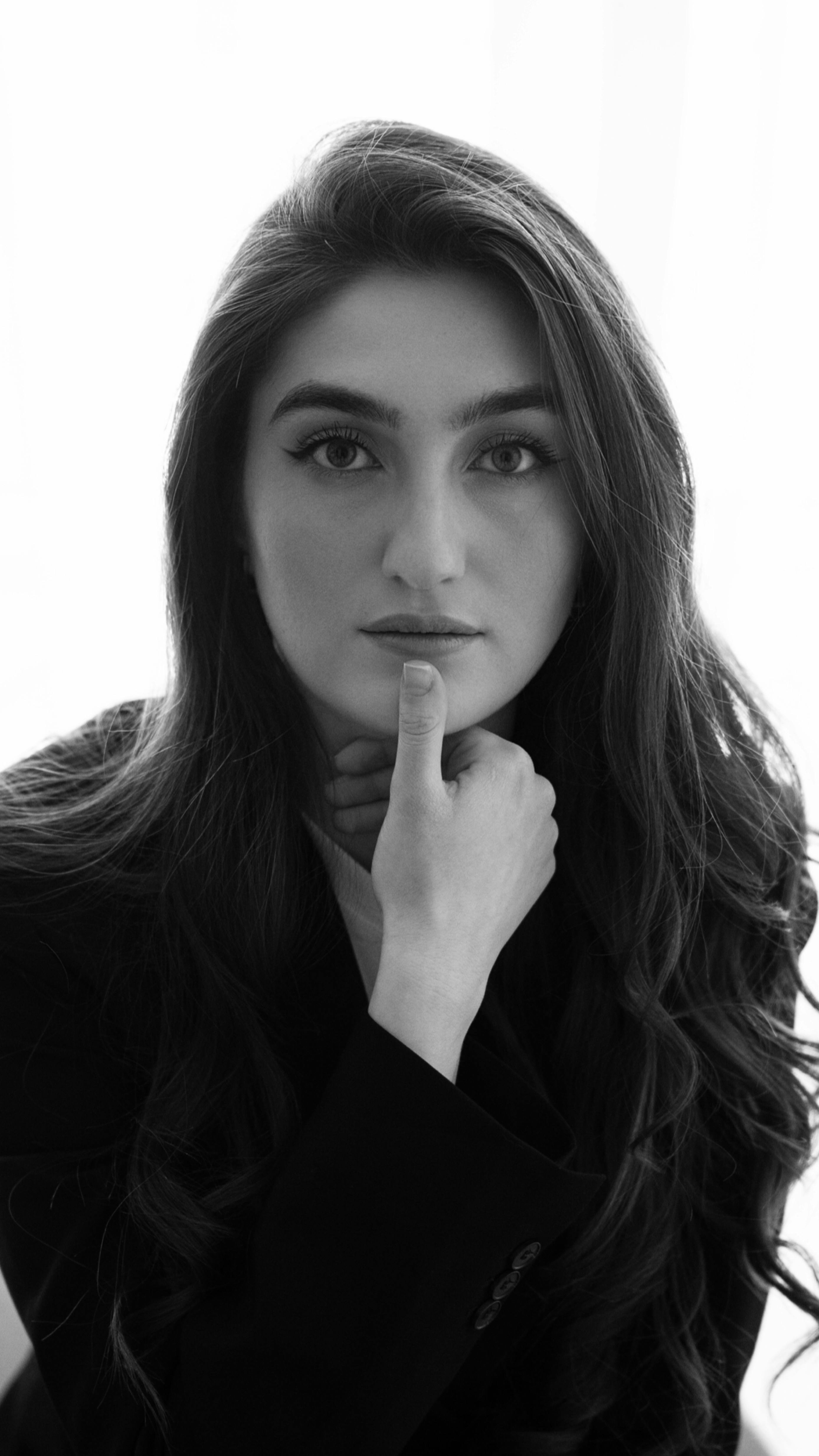 Artistic black and white portrait of a thoughtful woman indoors.