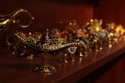 A collection of decorative genie lamps artfully displayed on a shelf in indoor lighting.