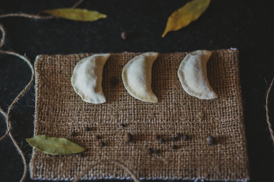 Plate of traditional Lithuanian cepelinai dumplings with sour cream and bacon