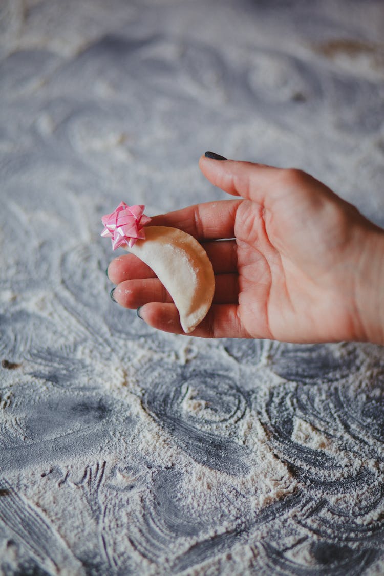 Empanada With Pink Star Gift Bow On Person's Hand