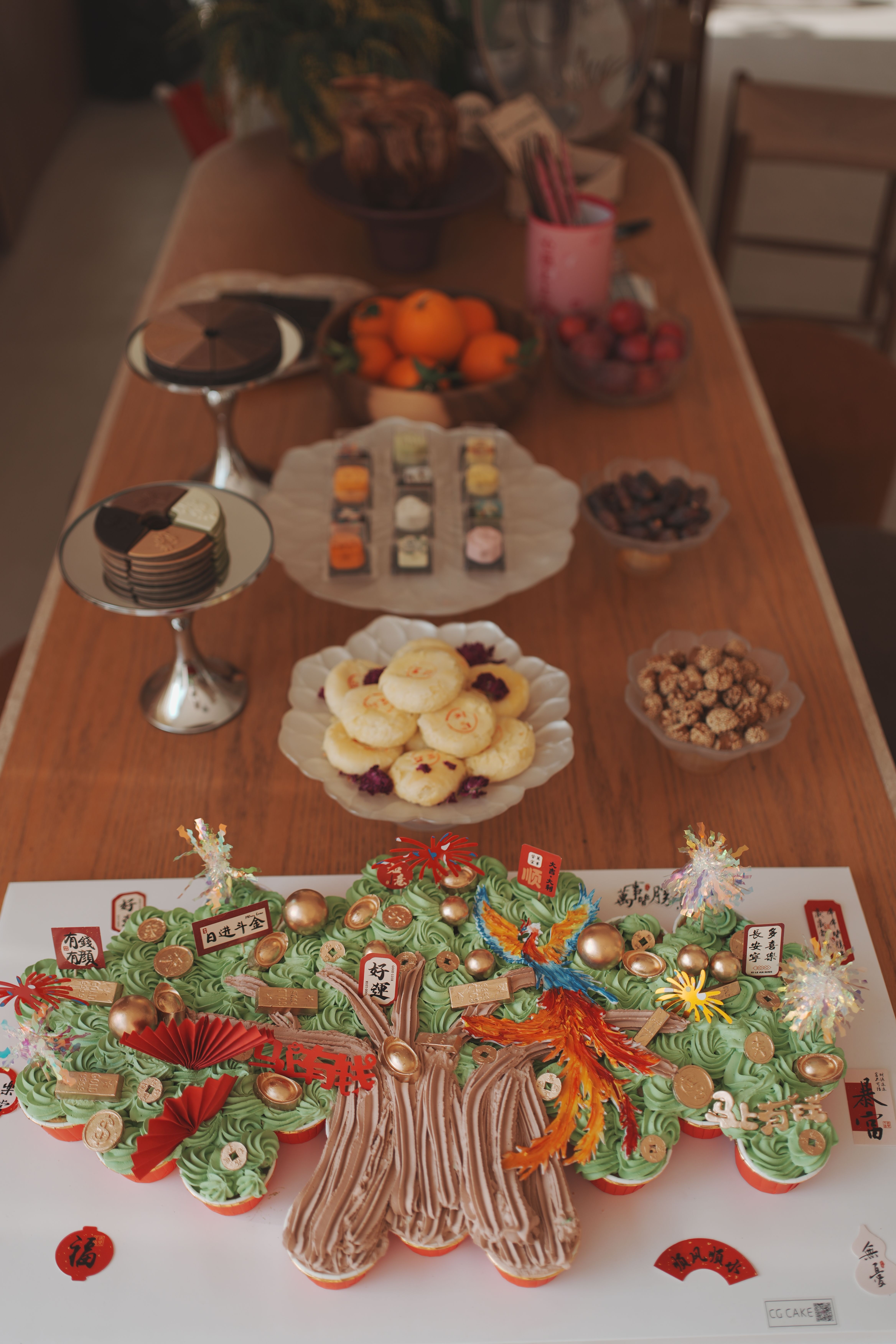A table with a decorative cake and assorted traditional treats, perfect for celebrations.