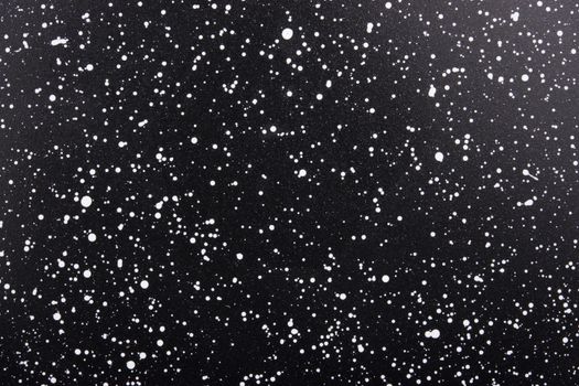 A high-resolution abstract texture of white speckles on a black background, reminiscent of a starry sky.