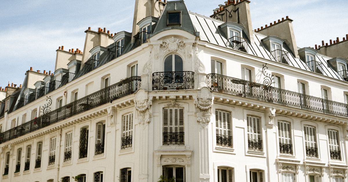 Charming Parisian architecture with classic details under a bright blue sky.