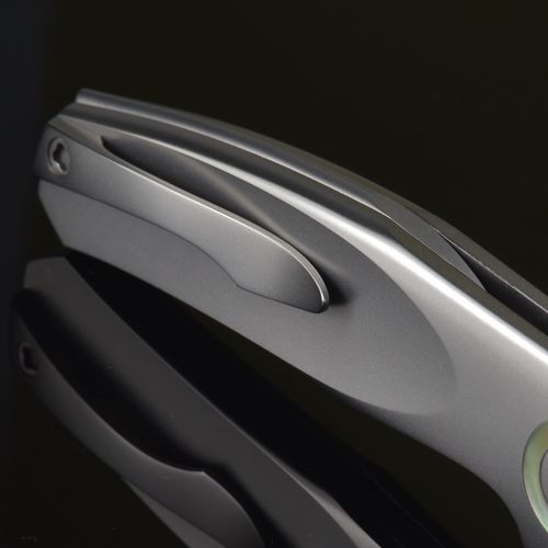 Free Close-up of a sleek metallic folding knife with reflections, showcasing modern design. Stock Photo
