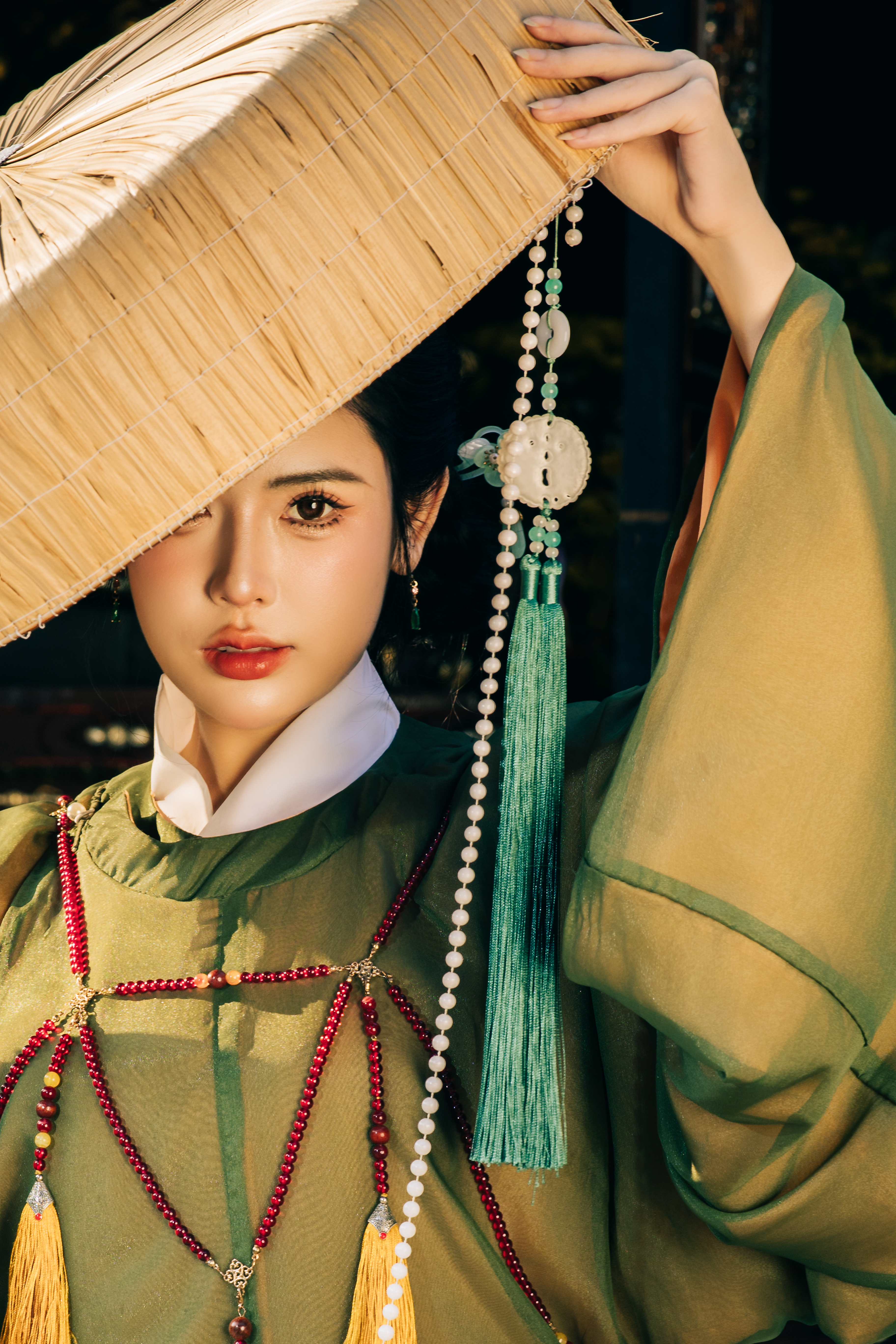 Portrait of woman in traditional Hanfu dress with a straw hat, showcasing cultural elegance.