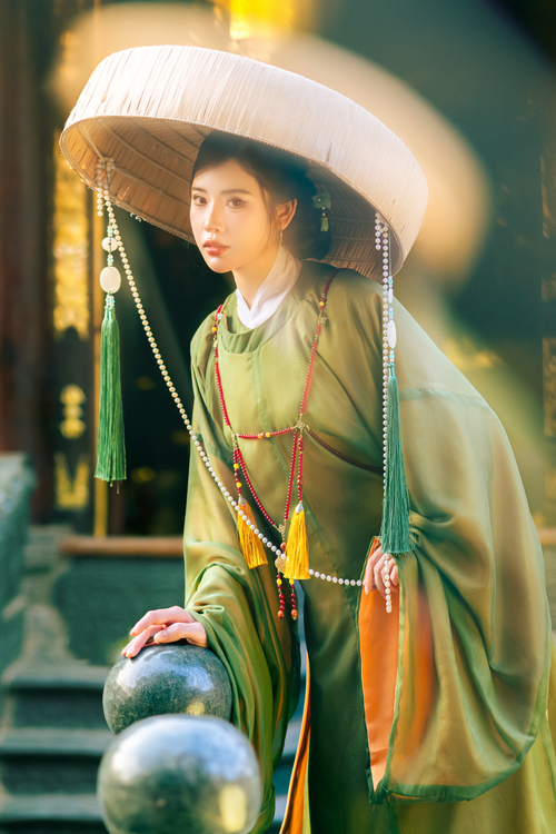 Free Woman in traditional attire with a large hat in a serene setting. Stock Photo