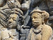 Detailed view of ancient bas-relief stone carvings on a temple wall in Indonesia.