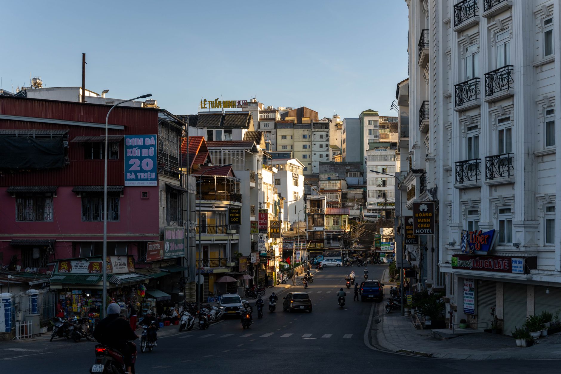 Urban street view with motorbikes and buildings in Dalat, Vietnam during the day.