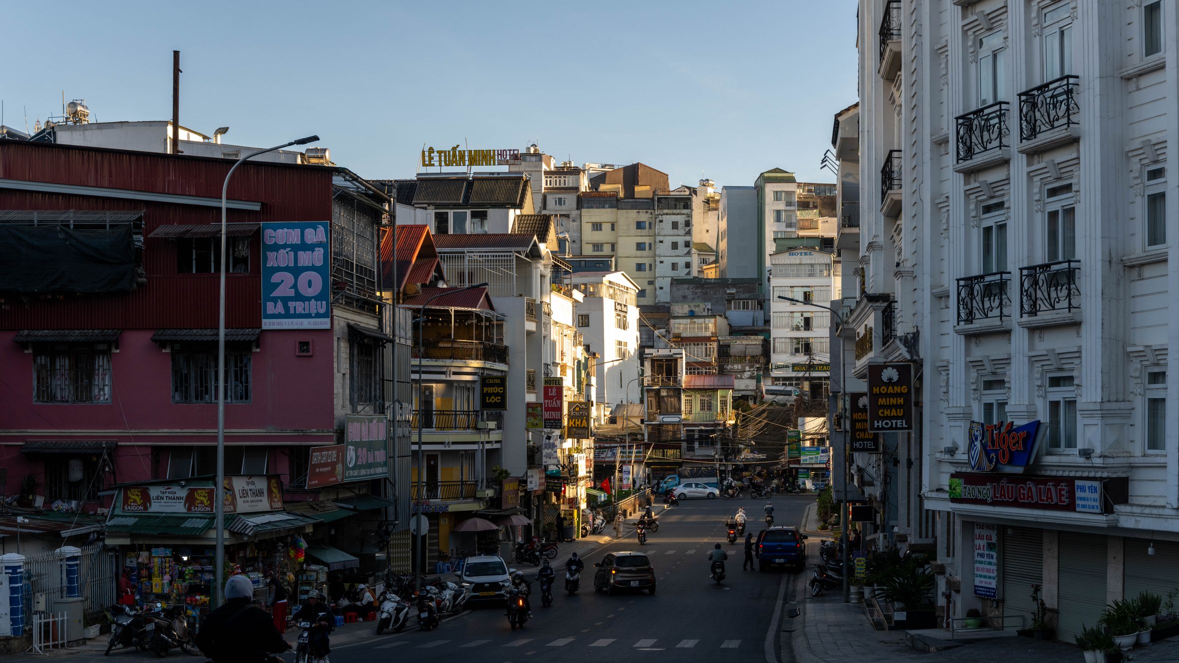 Urban street view with motorbikes and buildings in Dalat, Vietnam during the day.
