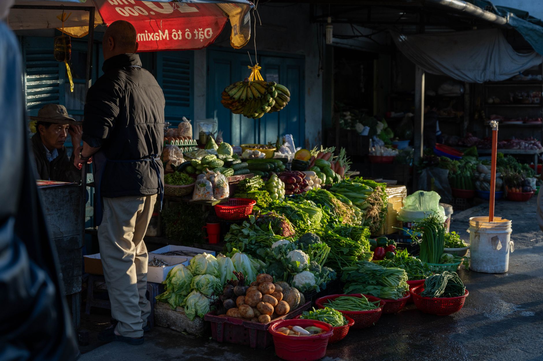 Street market in Dalat, Vietnam with fresh vegetables and early morning shoppers.