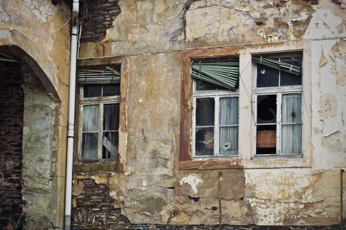 Free An old, weathered building with broken windows and peeling paint showcases urban decay. Stock Photo
