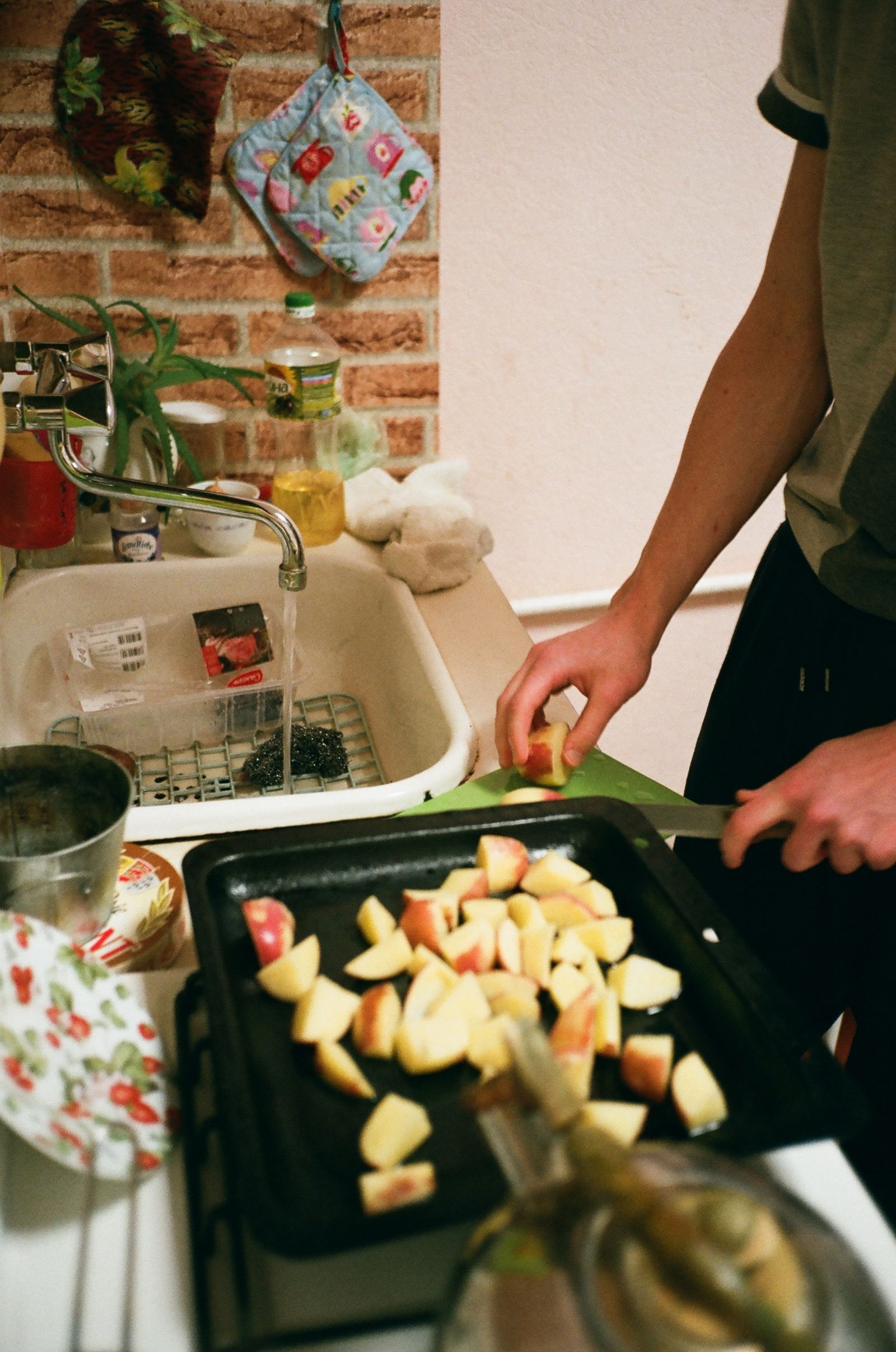 A person slicing apples in a cozy kitchen setting, emphasizing home cooking.