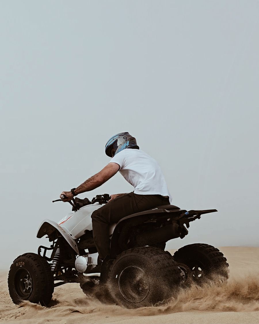 Pilote casqué et équipé au guidon de son quad