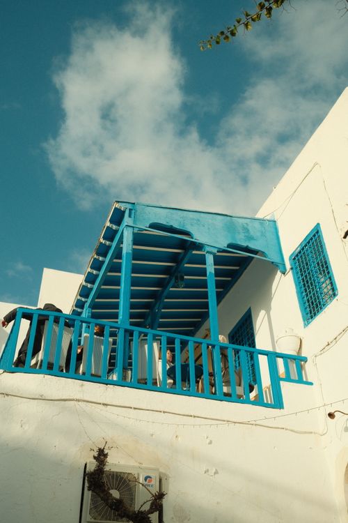 Free Charming Tunisian house with vibrant blue accents under a clear sky. Stock Photo