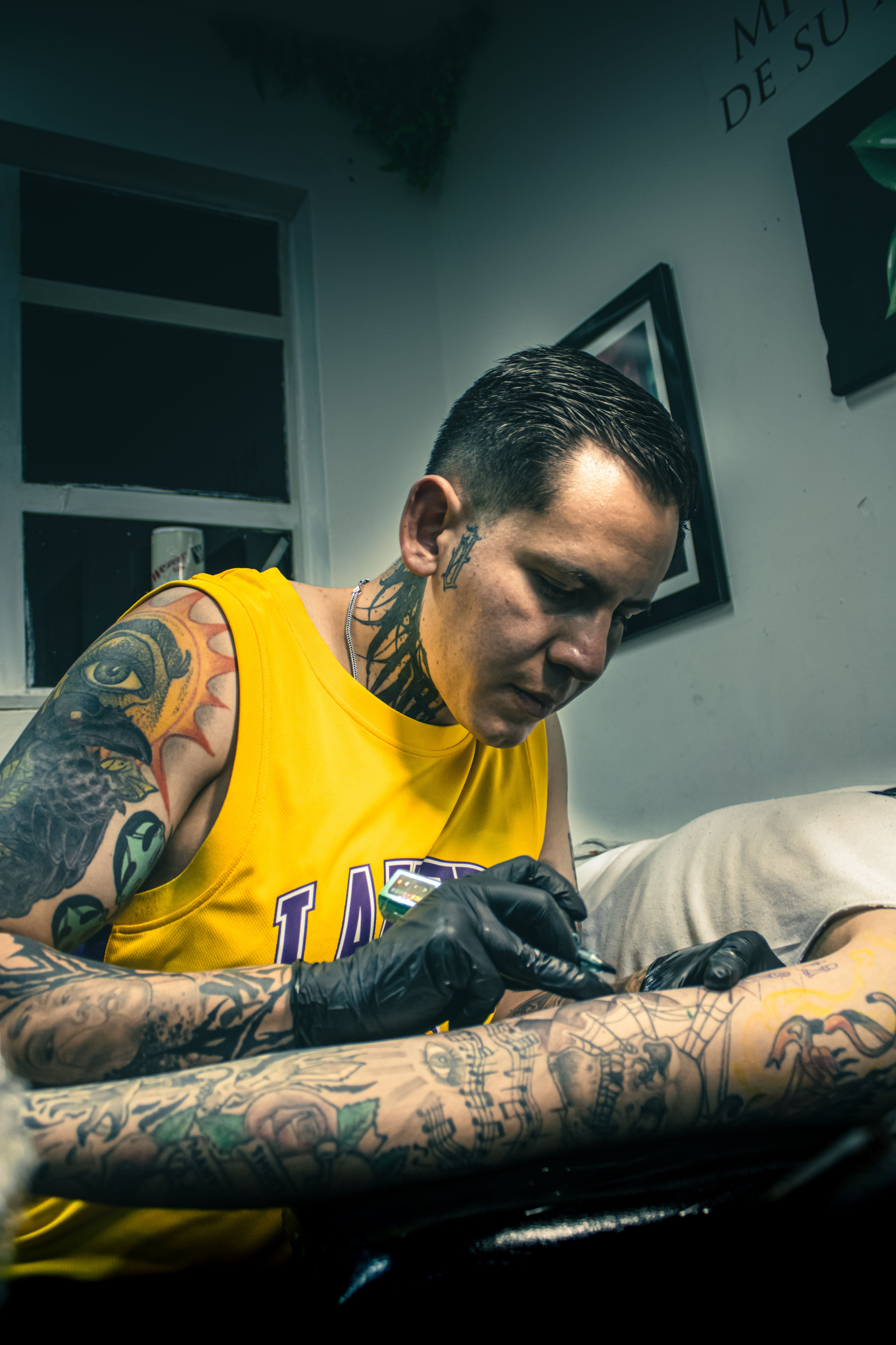 Professional tattoo artist creating detailed arm tattoo in Ciudad de México studio.