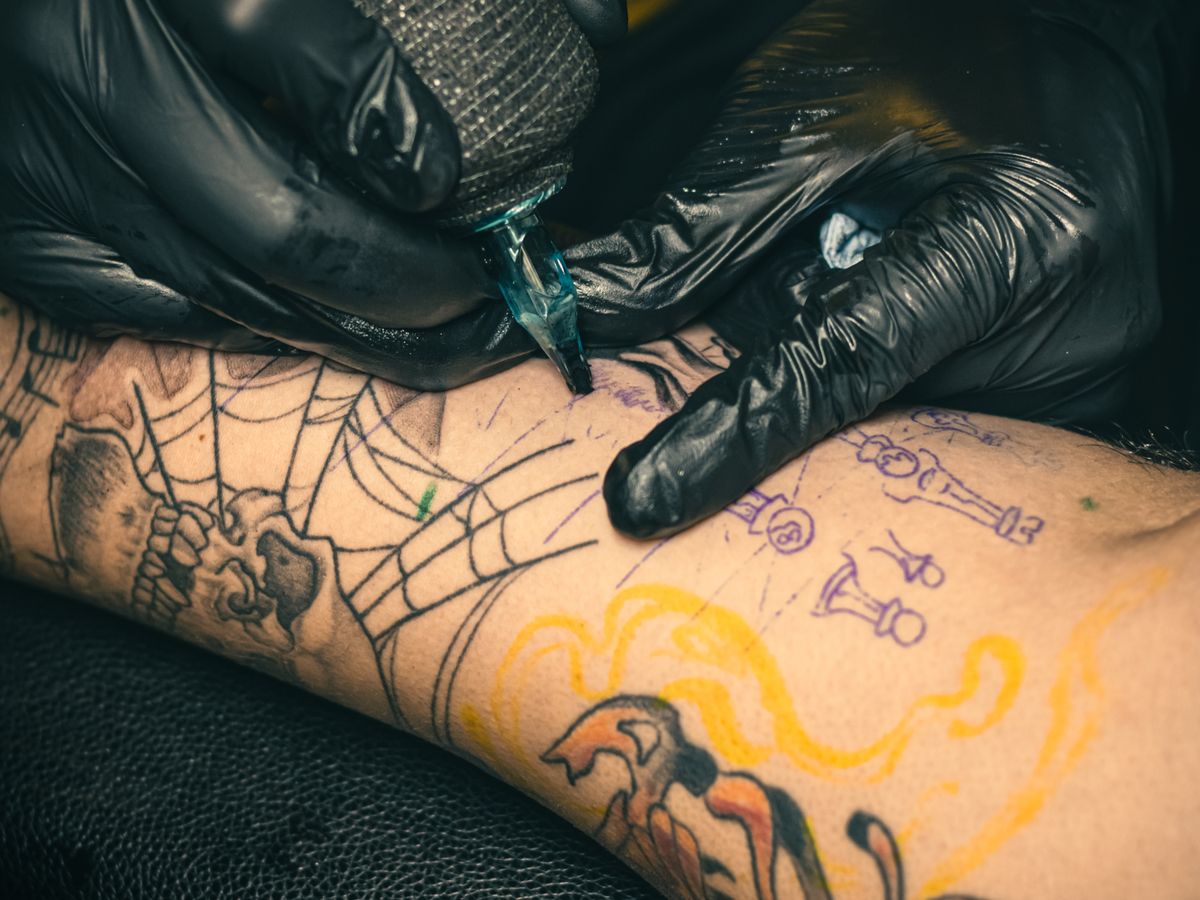 A close-up of a colourful phoenix full-sleeve tattoo.