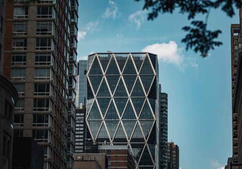 Dynamic view of a modern high-rise building in New York City with unique diamond pattern architecture.