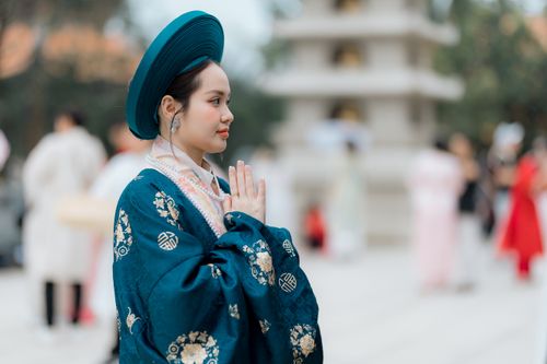 Free Woman in traditional attire with hands in prayer outdoors, serene mood. Stock Photo