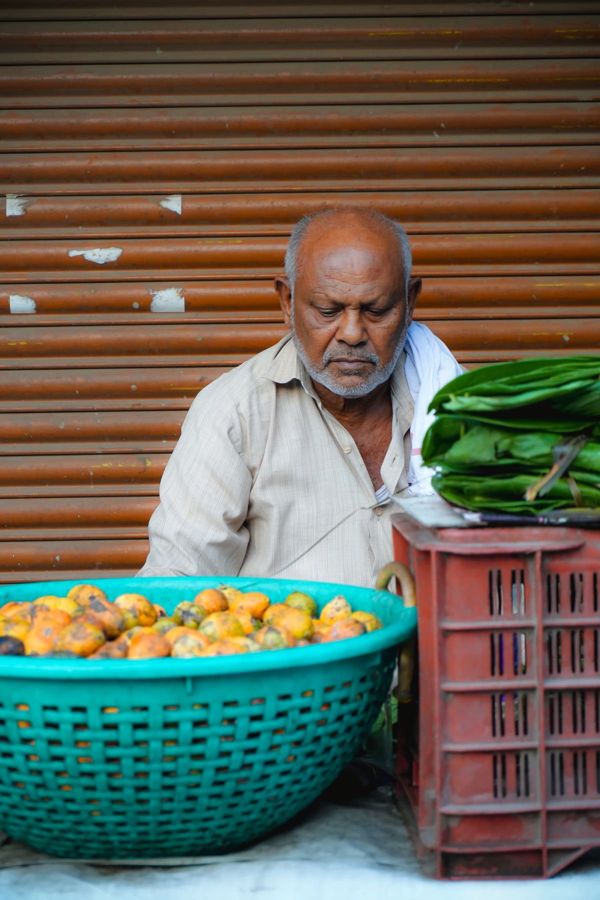 Elderly vendor at a fruit stall in a Cantonese market — the neighbourhood shopfronts wife cake grew up in