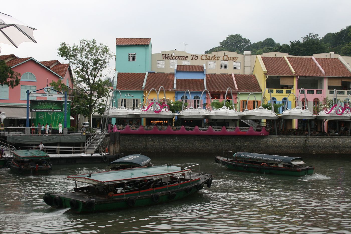 Colourful shophouses and river boats along the Singapore River at Clarke Quay by day