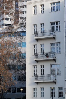 A contemporary urban apartment building with classic-style balconies and white facade.