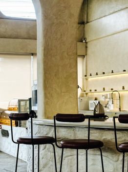 Minimalist café interior featuring bar stools and sleek design elements, ideal for urban lifestyle themes.