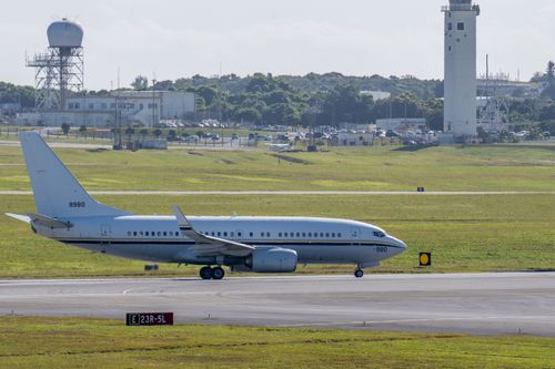 Free Commercial airplane taxiing on airport runway with control tower background in daylight. Stock Photo