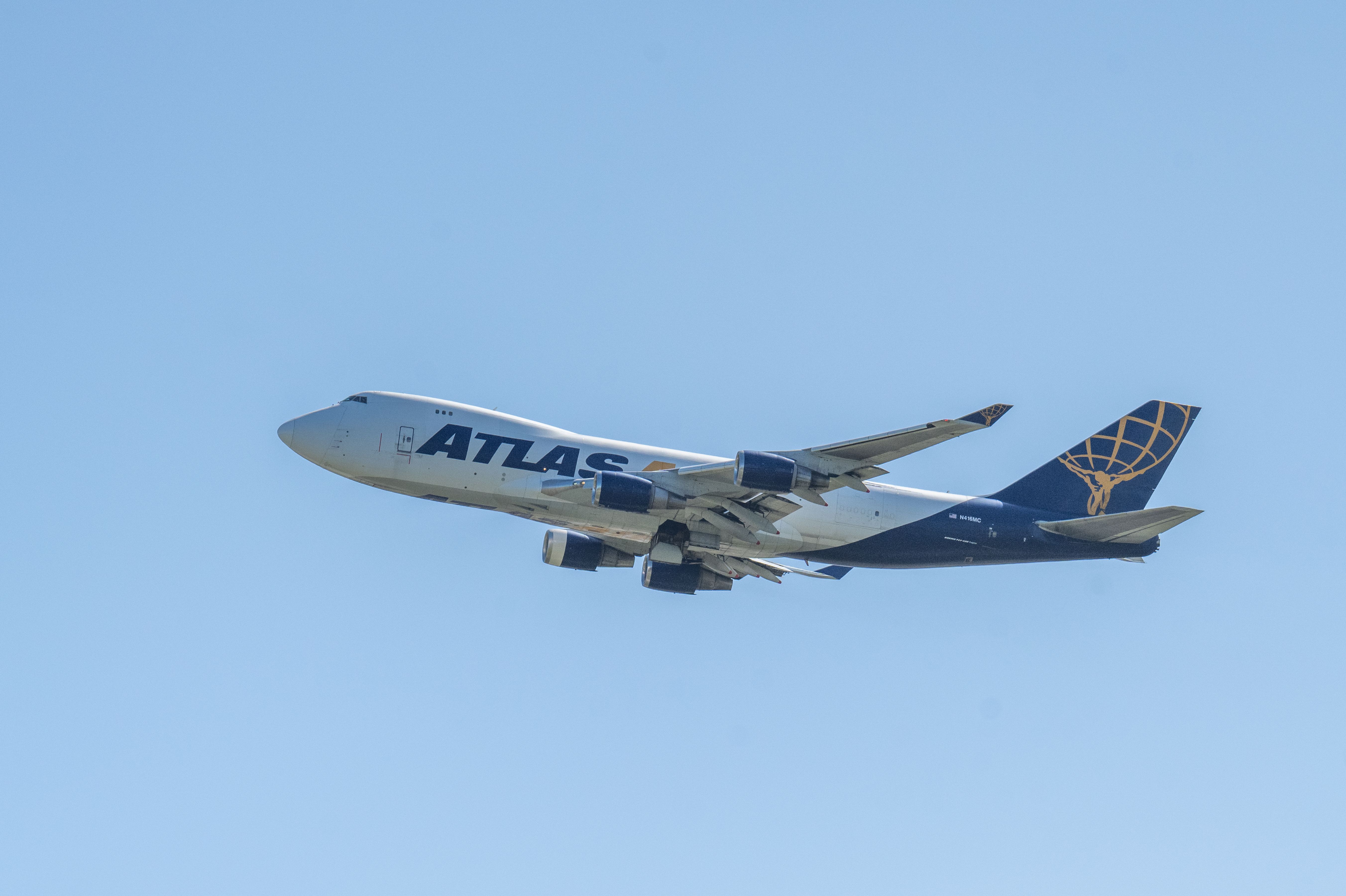 An Atlas Air Boeing 747 aircraft captured mid-flight against a clear blue sky, showcasing aviation technology.