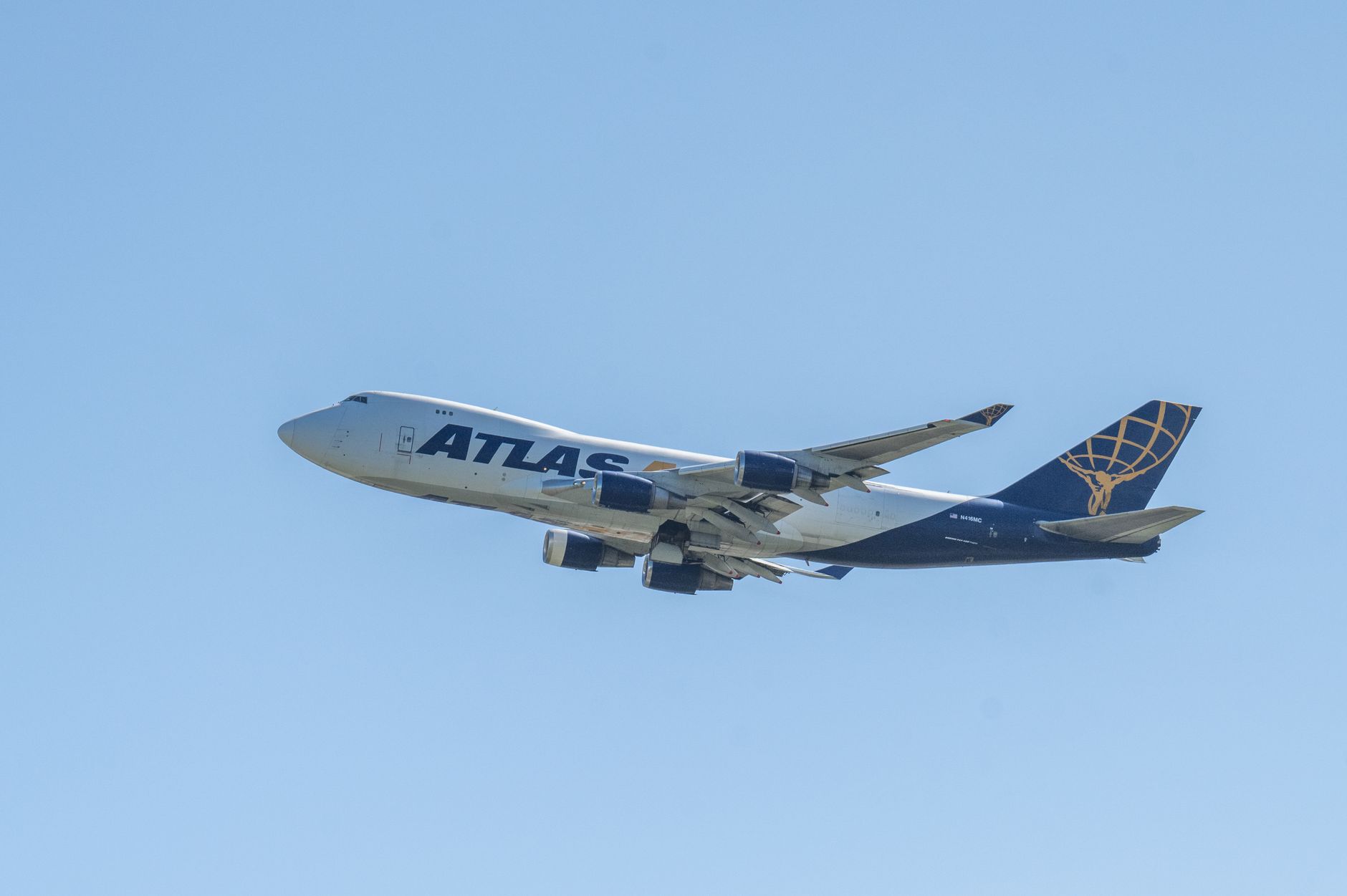 An Atlas Air Boeing 747 aircraft captured mid-flight against a clear blue sky, showcasing aviation technology.