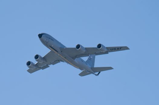 A US Air Force aircraft flying against a clear blue sky, showcasing aviation power.