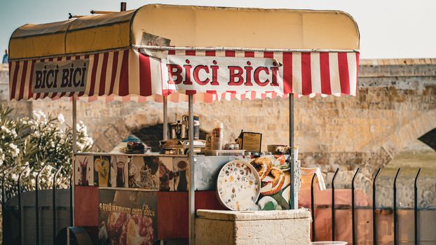Charming street food cart offering traditional treats in a historic outdoor setting with rustic charm.
