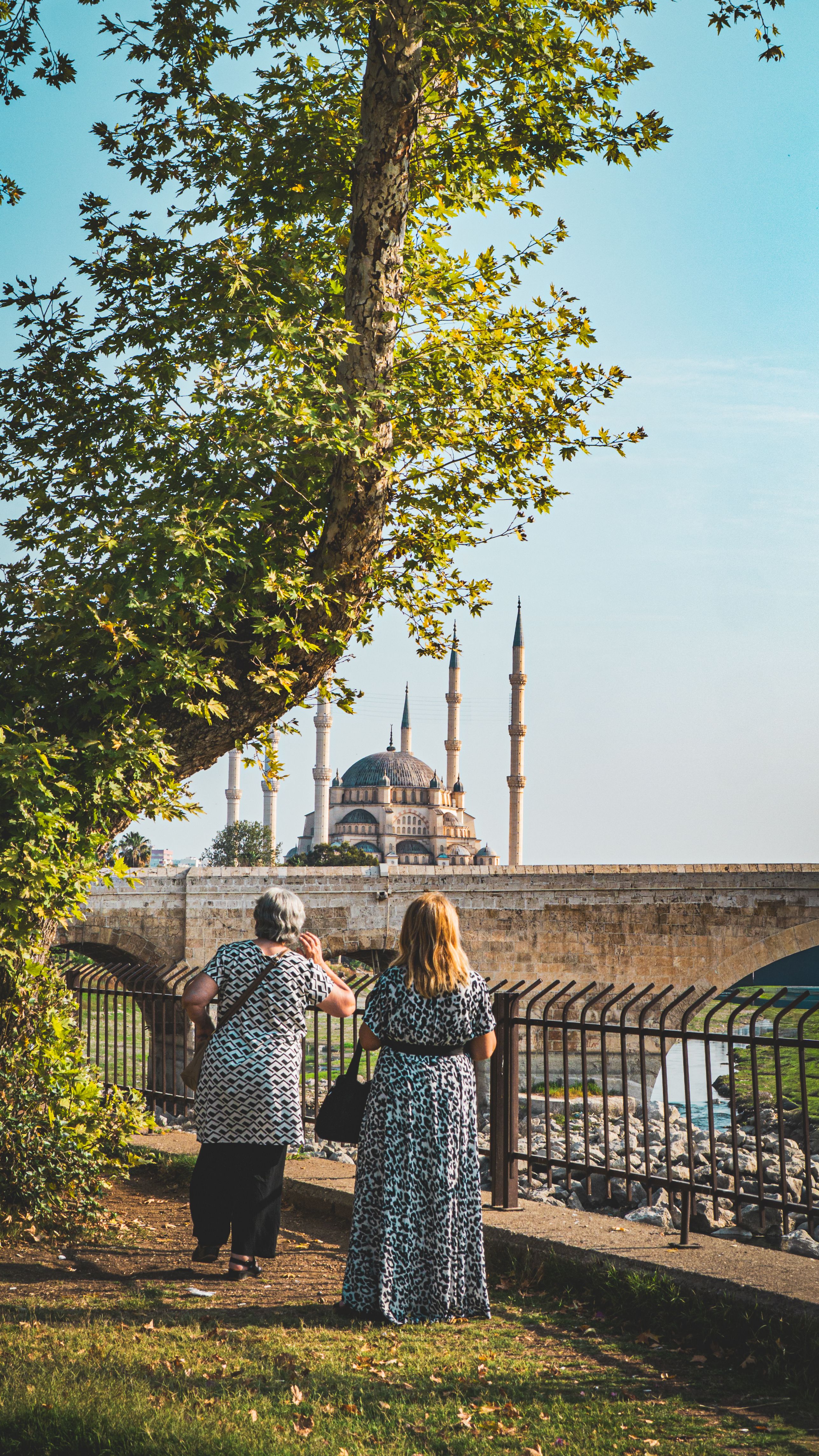 Two women viewing the iconic Selimiye Mosque in Edirne, Turkey, during a sunny day.
