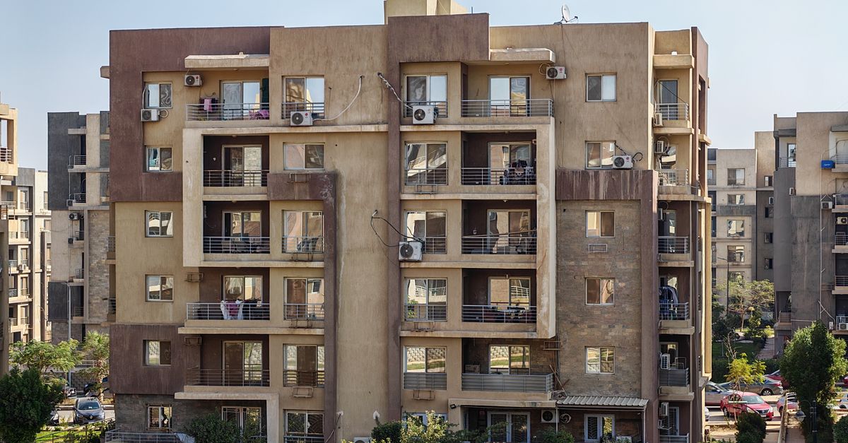 A contemporary apartment building with balconies in a cityscape.