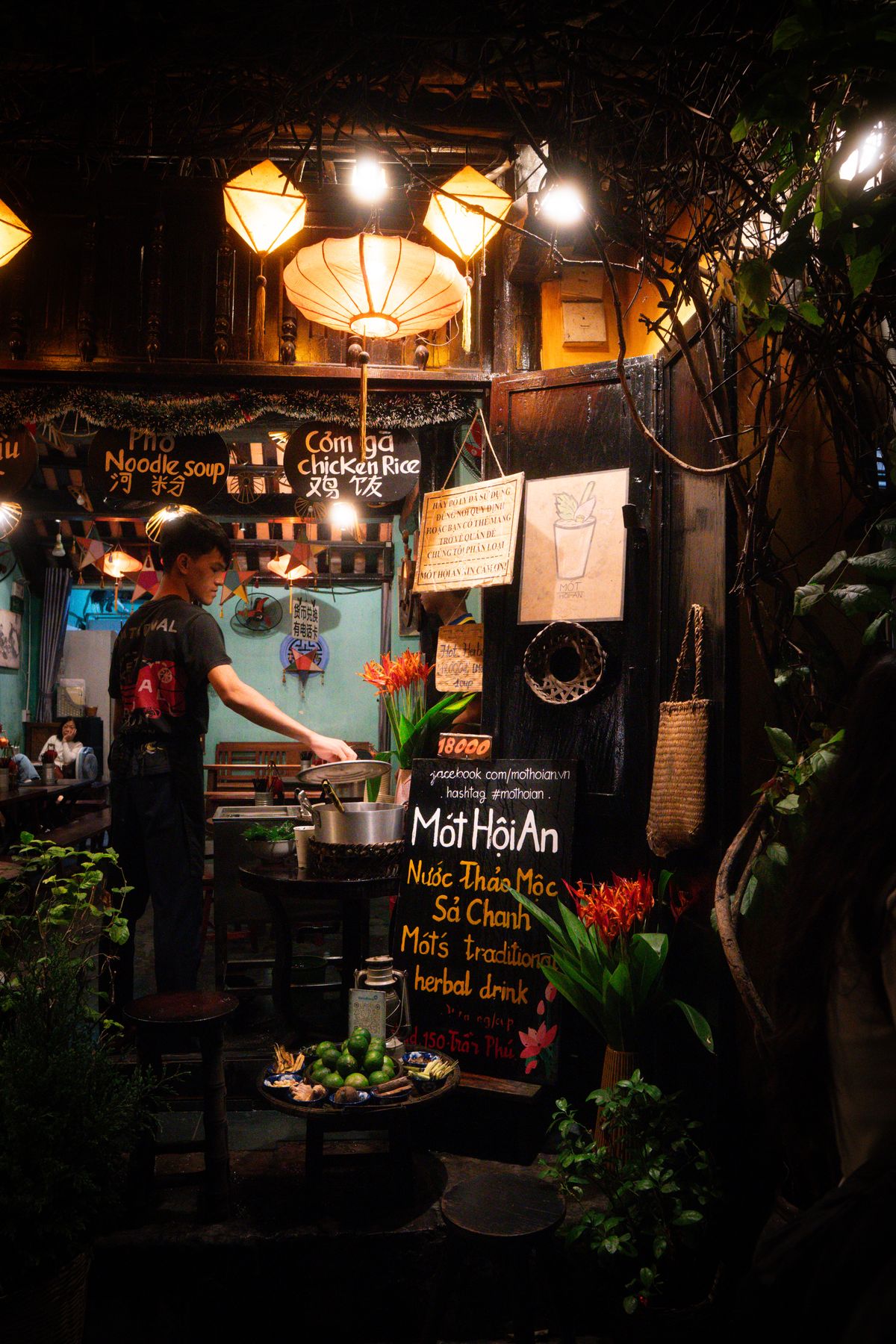 An illuminated drink stall on a Hoi An street at night