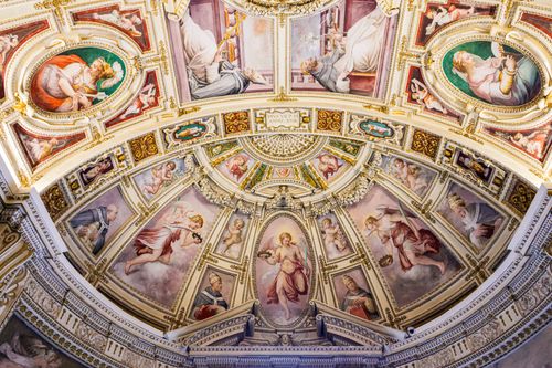 Free Detailed view of a lavishly decorated Renaissance ceiling with classical paintings and ornate designs. Stock Photo