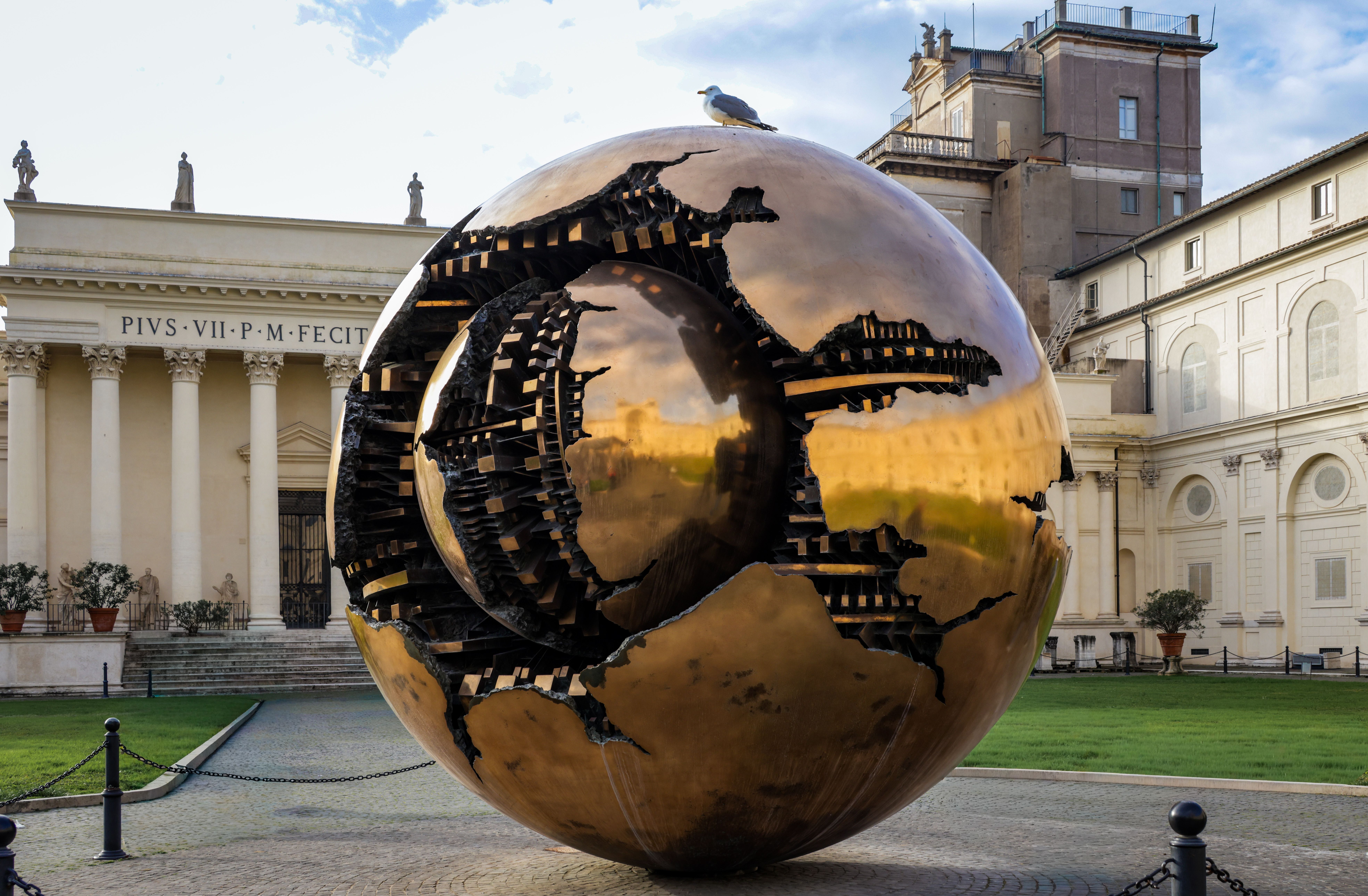 Modern metal sculpture 'Sphere Within Sphere' at Vatican City gardens.