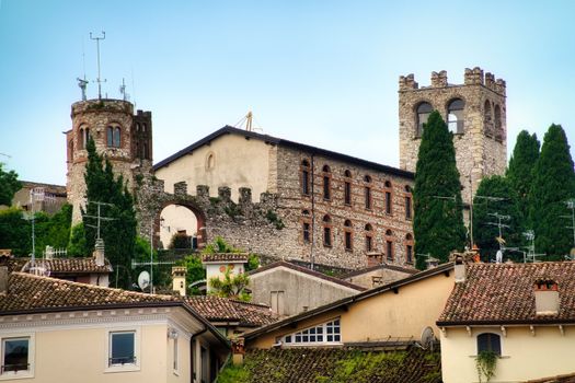 View of historic buildings and towers in Desenzano del Garda, Italy under a clear blue sky.